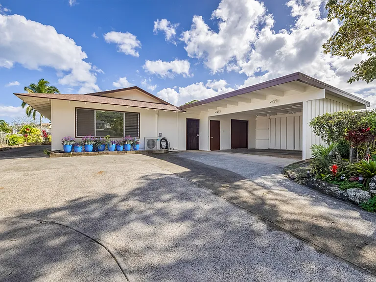 Front of house. 2-car carport with storage closets. Drive way to left side of house gives added parking.