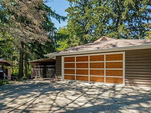  The detached garage with beautiful wood door is spacious and the carport offers added covered parking