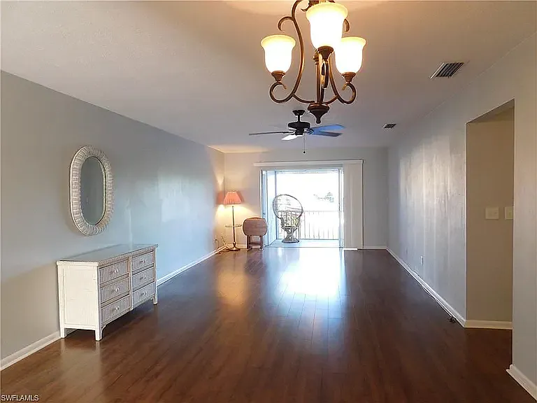 View of Livingroom area with sliding glass door out to back lanai. Primary bedroom is off to the right.