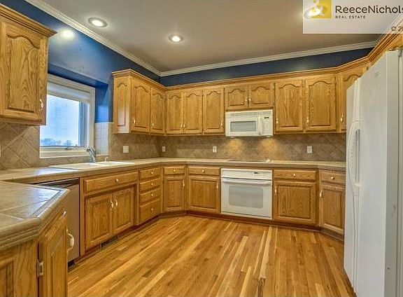 Beautiful kitchen with recently refinished hardwood floors.  Til