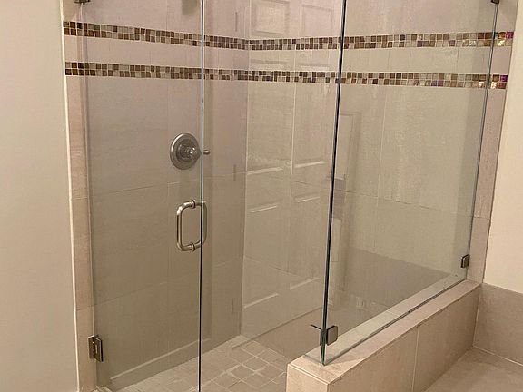 The walk-in shower features designer Delta fixtures.