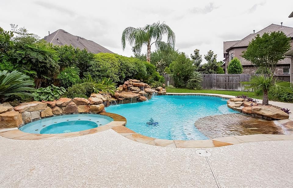 A Tropical Paradise in your Own Back Yard Featuring a Beach Entry, Dual Waterfalls, Pool and Spa! NEVER FLOODED, this home features Programmable Sprinklers Front and Back, a Water Softener and Drinking Water System.