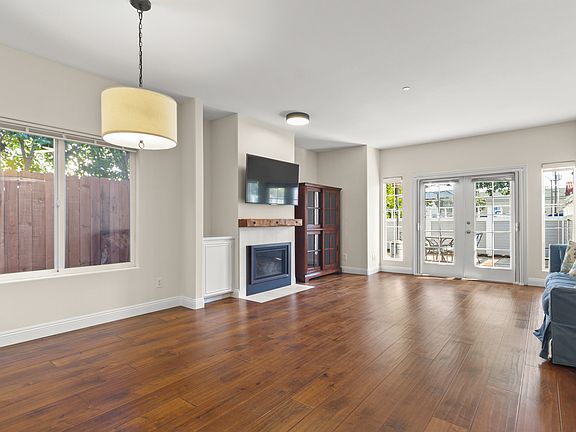 Large great room with fireplace and french door opening to lovely patio