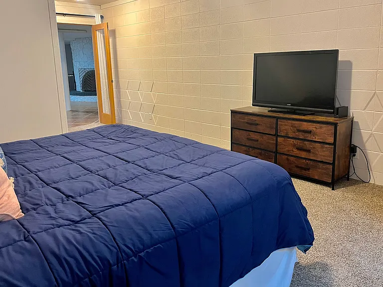 Master bedroom with ensuite bathroom, TV, and amoire