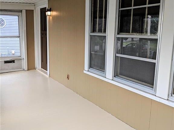 Fully enclosed front porch- a spacious place to sit and relax, use as a mudroom and/or plant haven.