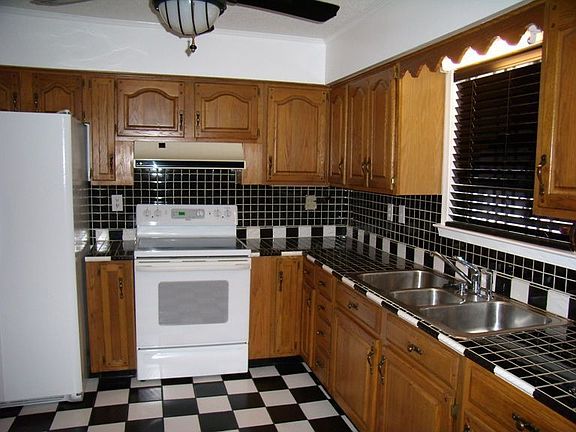 Kitchen has ceramic tile on floor and counter tops