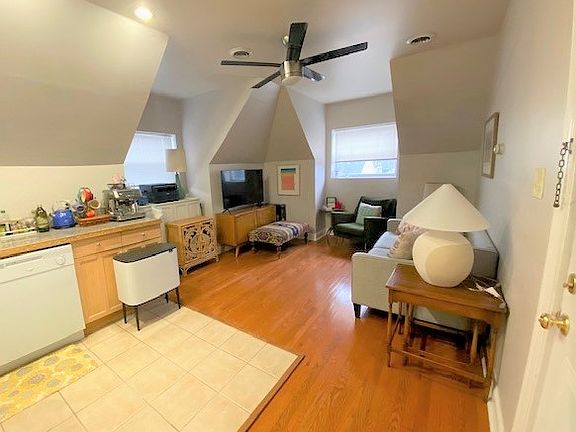 Entrance view towards living room. 
Sleek ceiling fan and beautiful hardwood flooring.
