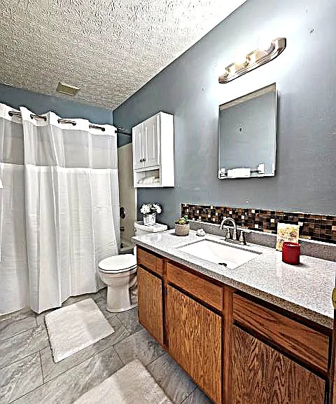 1st floor prime bedrm bath - tub/shower, sink, commode, medicine cabinet, cabinetry, new light fixture.