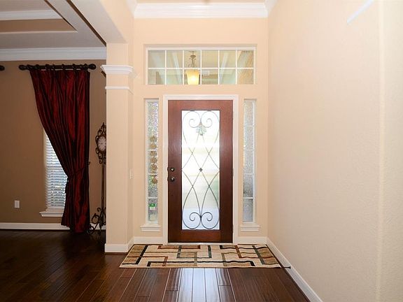 What a great way to greet your guests in this pretty foyer with high ceilings, crown molding and lots of windows.