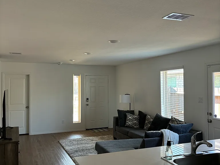Living room, front door, and laundry/garage door looking from the kitchen