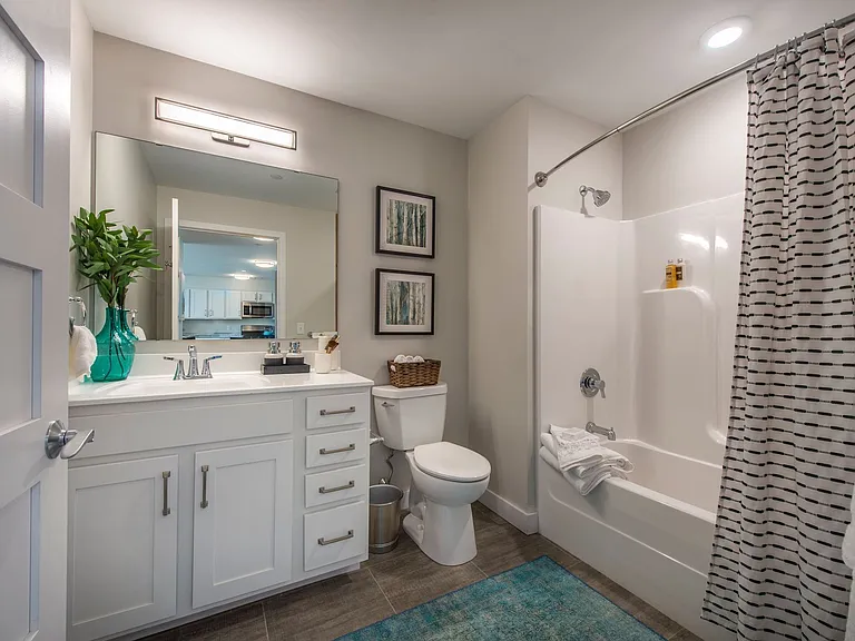 Brand New Bathroom with Tub and Shower Combo, white cabinets and white faux quartz counters.