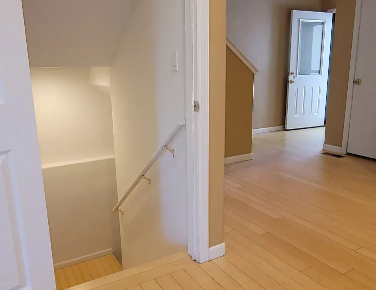 Looking back to the entry from the kitchen island and down the stairs. Garage door is on the right.