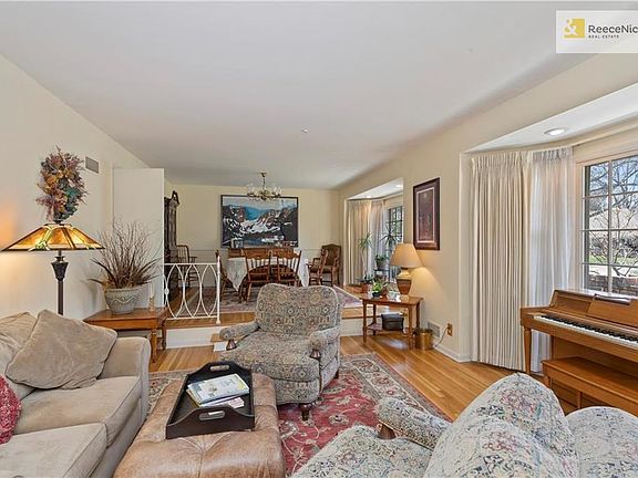 The living room and dining room enjoy lush natural light from the large bay windows overlooking the front yard.