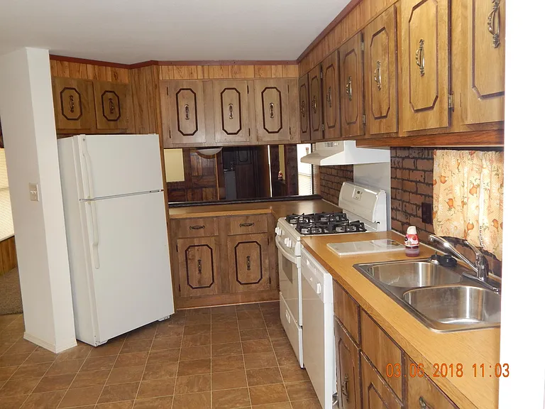 Showing view from kitchen past sink and appliances -showing cabinets.