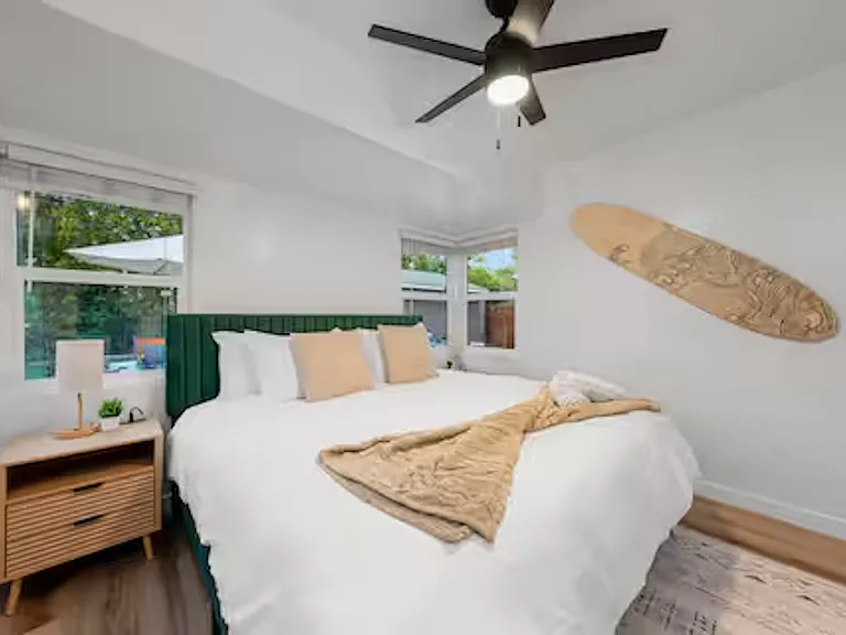 Bedroom 2 is bright and airy with windows and blackout blinds, featuring a king bed, ceiling fan, and a lampshade with extra outlet and USB ports for easy device charging. Ample closet space completes this comfortable and convenient retreat.