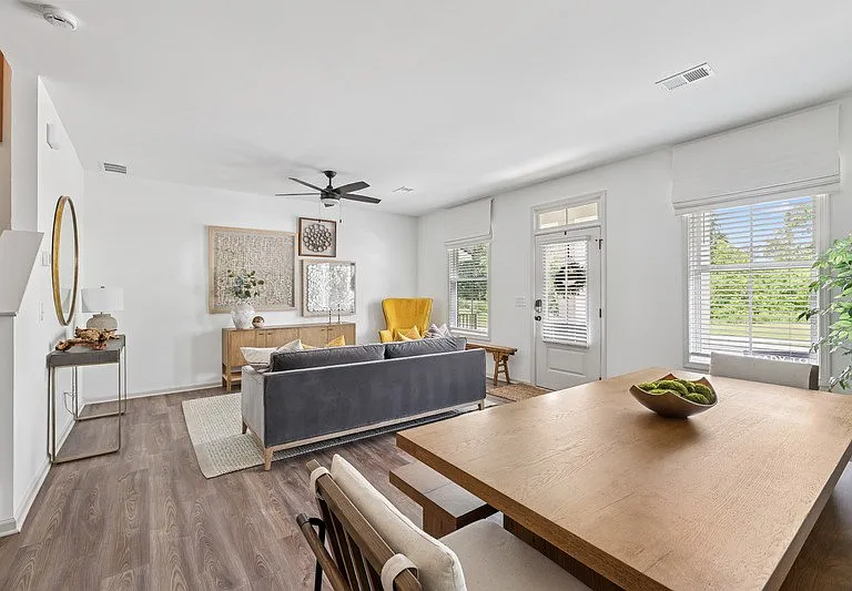 Living room with large couch, accent chairs, and windows.