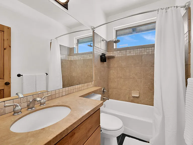 Man floor full sized bathroom with tub and shower