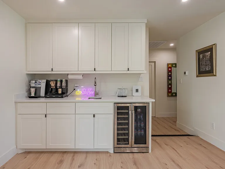 Stylish built-in coffee and beverage station with custom cabinetry, sink, and undercounter beverage cooler - perfect for entertaining and daily convenience.