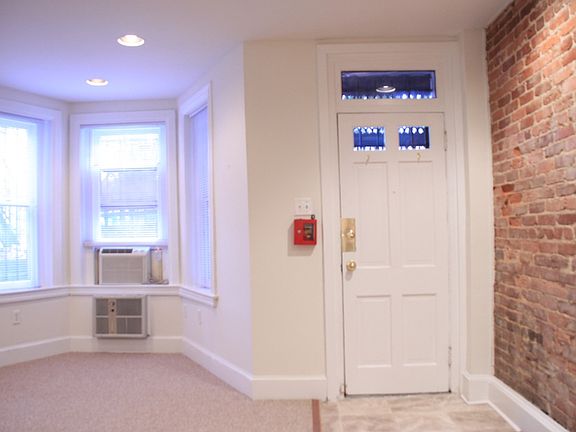 Front door, featuring bay window & brick wall