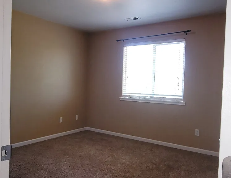 Window of the second bedroom and the shared wall with the next townhome.