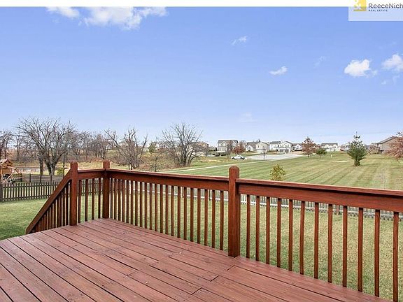 The over-sized deck off the kitchen/dining area leads to the large, level backyard. Notice the adjoining green-space, and close proximity to the neighborhood walking trail and pool.