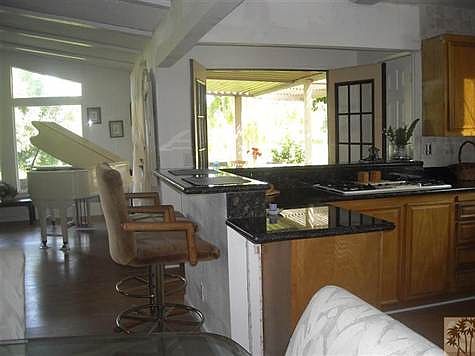 Kitchen has been remodeled with granite counters and sandwich bar, and opens to the outside dining area.