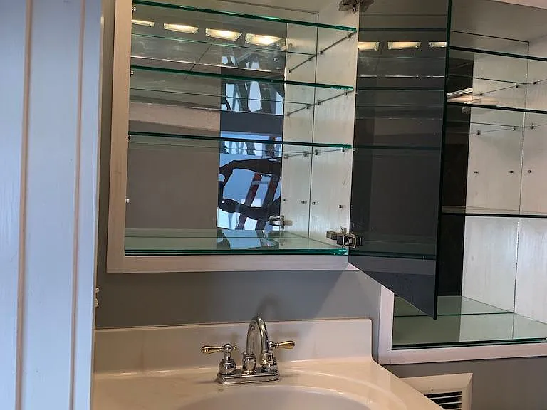 Full bathroom, large cabinet above sink behind the bathroom mirror.