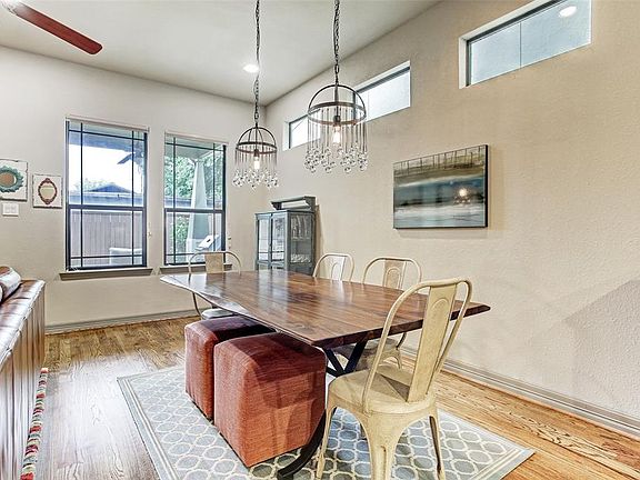 Over-sized dining area features a pair of gorgeous contemporary light fixtures.