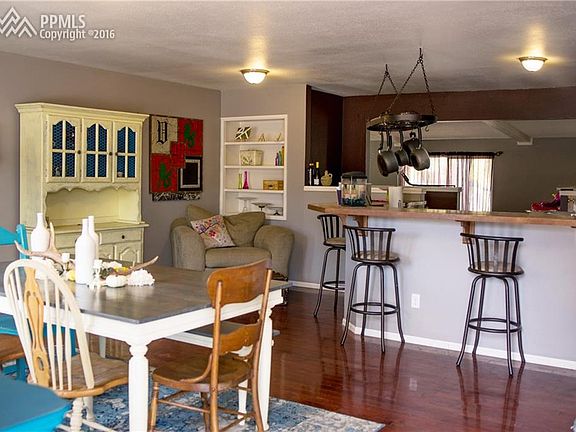 Living room with hardwood floors, built-ins and open to kitchen with breakfast b