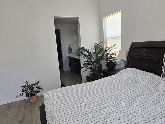 Spacious master bedroom with a walk-in closet, featuring plenty of natural light and stunning views of the park and mountains through the window.