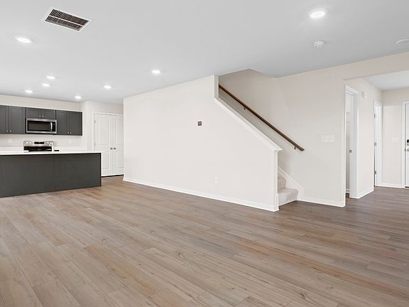 Open 1st floor living room and kitchen in a DRB Homes Glenshaw plan at The Village of College Park.