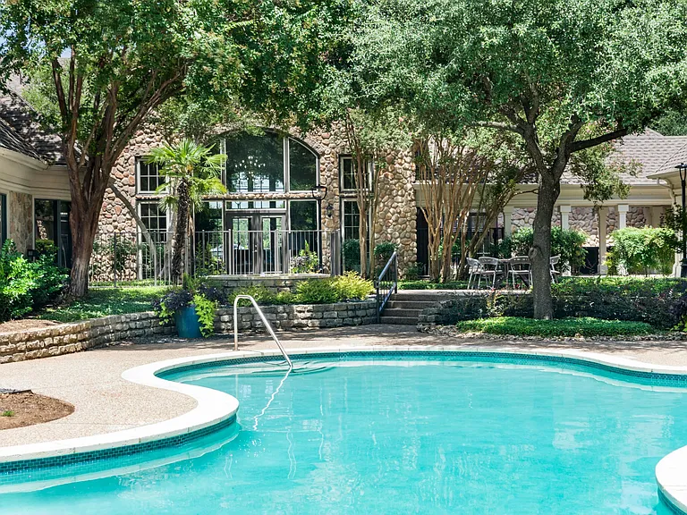 Cool off or unwind in the sparkling swimming pool surrounded by mature trees and peaceful outdoor seating areas.