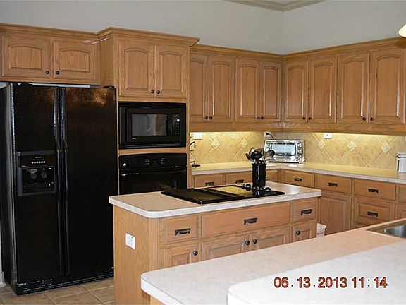 Open Kitchen with custom cabinets galore! Island kitchen, electric stove and grill. Undercabinet lighting. Ready for a party!