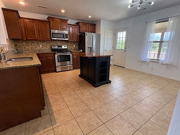 Kitchen includes fridge, convenient pantry, and adjustable-size island.