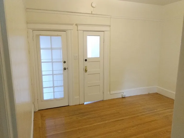 Living room - door on left to stairwell entrance + door on right to front office space