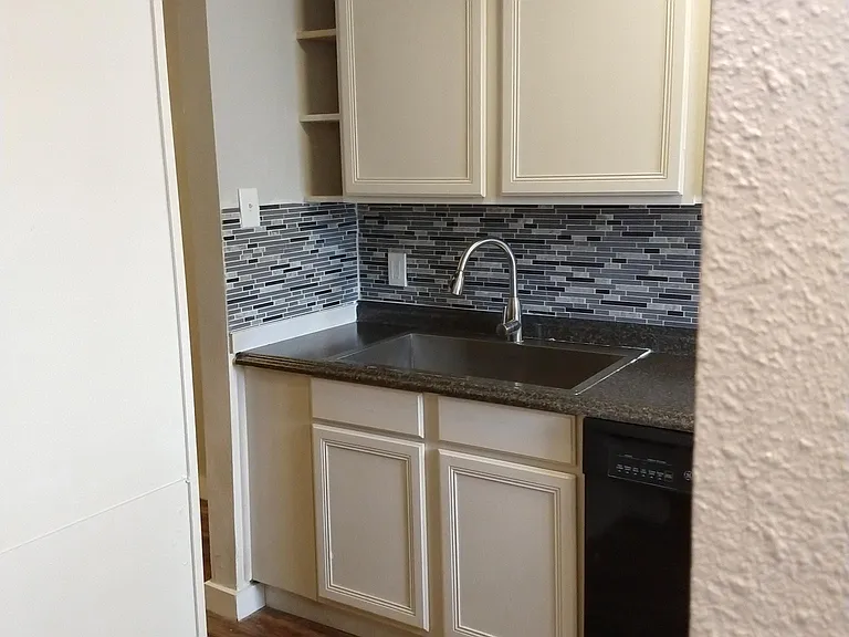 The kitchen has updated appliances, new backsplash, repainted cabinets, and new wall and ceiling paint.