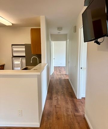 Hallway to bedrooms, with a small tv attached to the wall