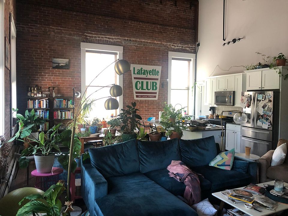 Bright large living space with open kitchen. Kitchen appliances include stainless steel fridge with wine/can drawer, dishwasher, gas stove, microwave