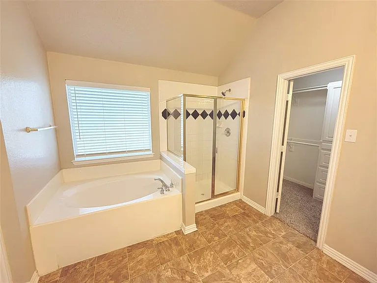 VIEW OF TUB AND SHOWER AND WALKIN CLOSET IN THE MASTER.
