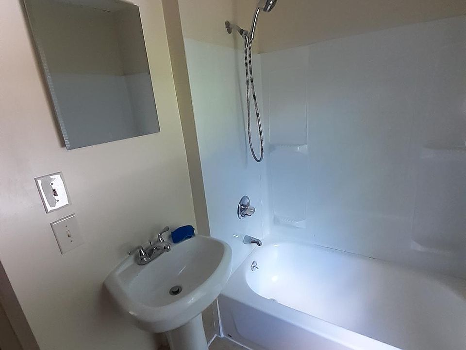 Bathroom with ceramic tile floor, pedestal sink, and removal shower head