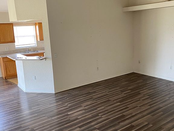 Family room with plant shelf leading to dining and kitchen area