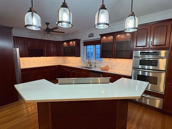Quartz Countertops, Maple Cabinets with under cabinet and internal hardwired lighting, Oven/Microwave Combo, Island (seats 4). New fridge (2024), Dishwasher (2024).