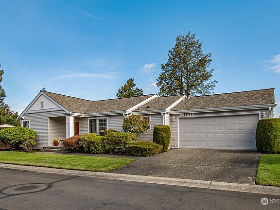 Not only does this beautifully manicured property exude curb appeal, but it also offers plenty of parking with an enclosed garage and ample driveway.>