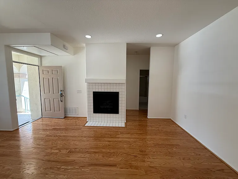 View of living room, front door and fireplace.