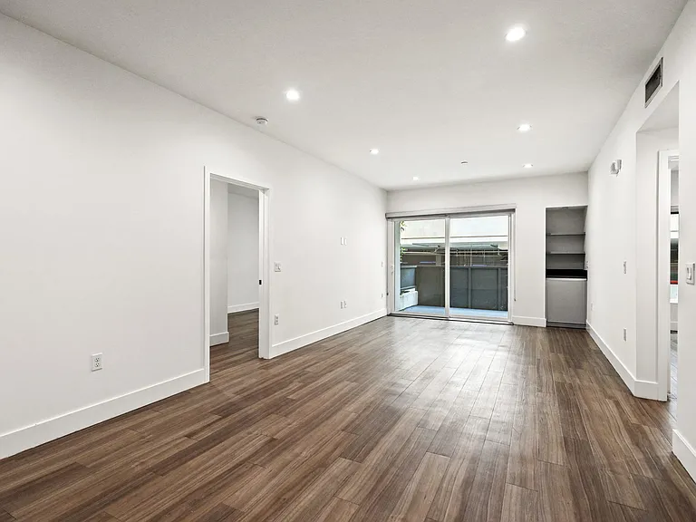 Living Room with Built-In Storage, Patio, and Vinyl Flooring