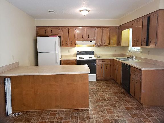Kitchen with breakfast bar, stove, refrigerator and dishwasher. Good counter and cabinet space.