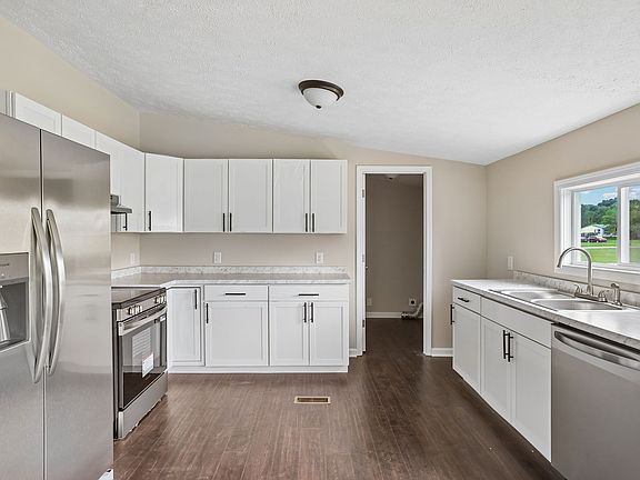 Renovated kitchen with white shaker cabinets, marble-look counters, and stainless Frigidaire appliances.