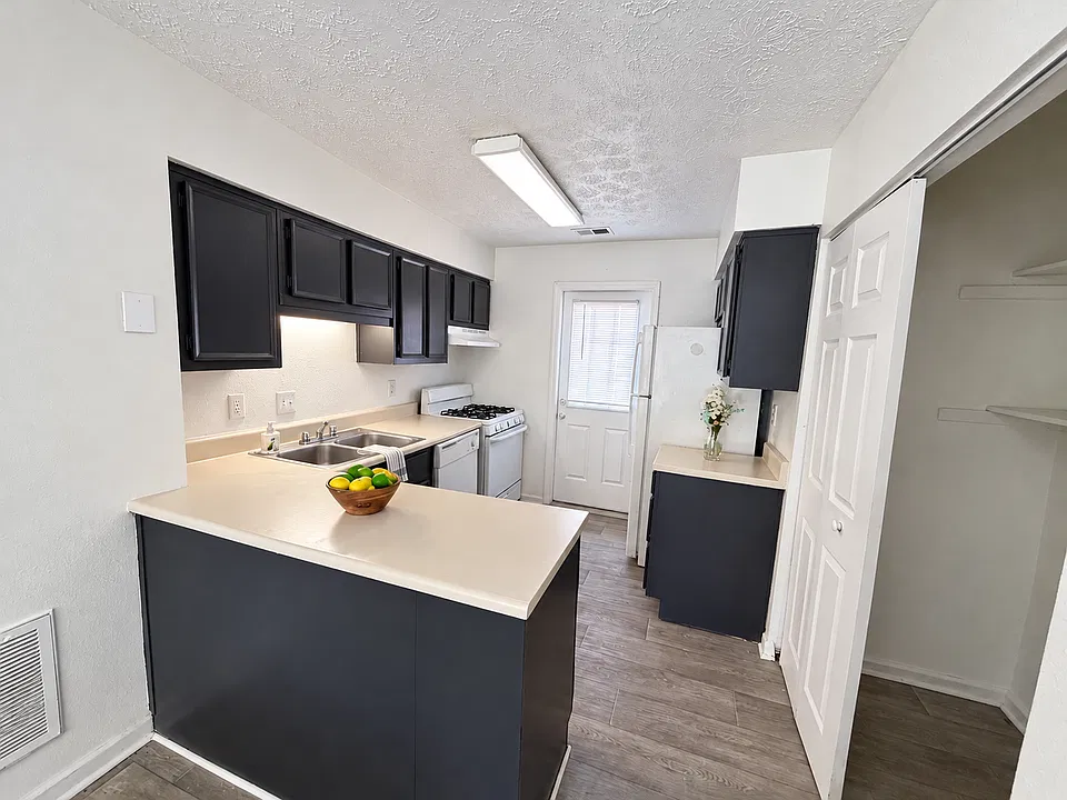 Kitchen with dark cabinetry and white appliances.