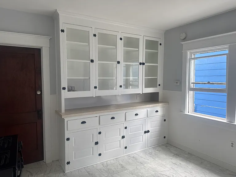 Beautiful built-in glass-front cabinets offer abundant storage and display space. Granite countertops, ample lower cabinets, and a spacious dining area with plenty of natural light create a functional and inviting space for everyday living.