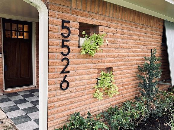 A fresh contemporary feel imparted by architectural address numbers, Bahama shutters and checkered tile entry